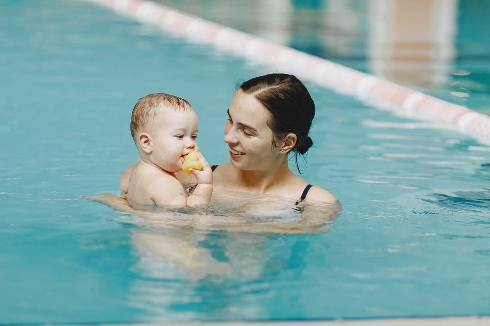 Mutter mit süßem Baby im Schwimmbad